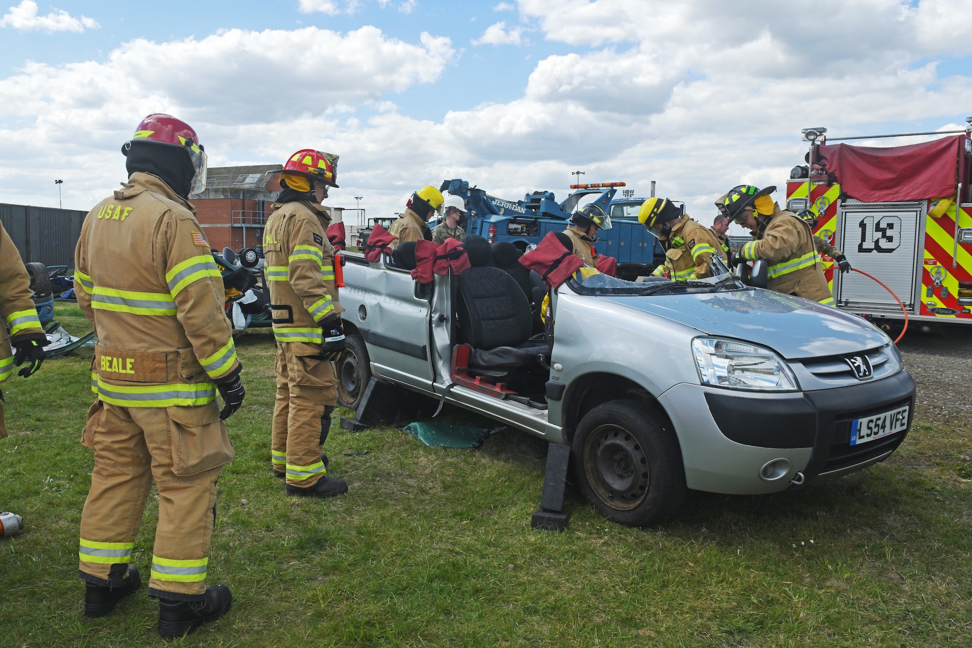 Firefighters assigned the 100th Civil Engineer Squadron prepare to expand the front of a simulated crashed vehicle during training with the 100th Logistics Readiness Squadron at Royal Air Force Mildenhall, England, May 7, 2021. By expanding the front of the vehicle, first responders are better able to remove passengers from the vehicle without potentially causing further bodily harm. (U.S. Air Force photo by Staff Sgt. Mackenzie Mendez)
