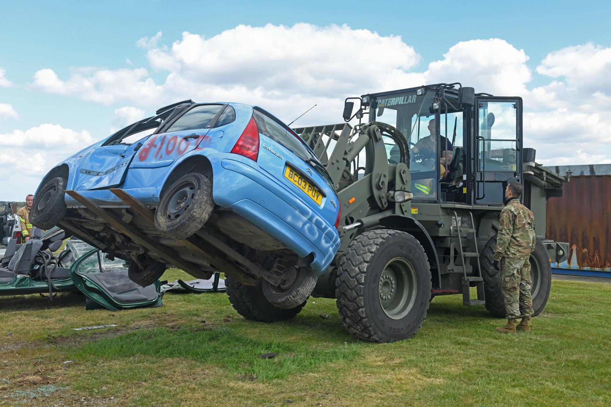 U.S. Airmen assigned to the 100th Logistics Readiness Squadron instruct 100th Civil Engineer Squadron firefighters on how to properly operate a forklift and dispose of crashed vehicles during training at Royal Air Force Mildenhall, England, May 7, 2021. During the training, each unit trained the other on best practices and procedures when handling vehicle crash sites. (U.S. Air Force photo by Staff Sgt. Mackenzie Mendez)