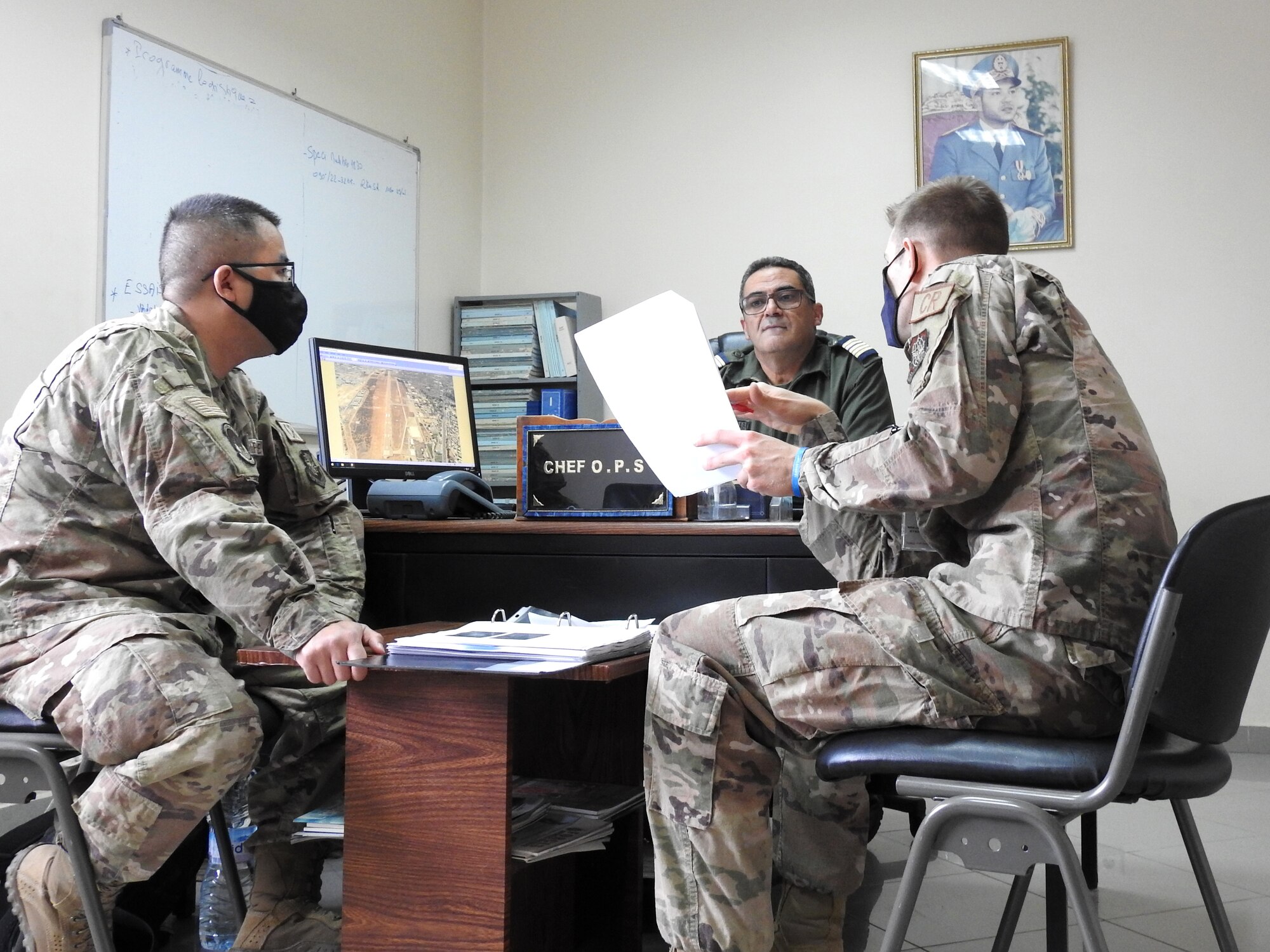 Capt. Jack Robinson, 821st Contingency Response Support Squadron airfield assessment team chief and civil engineer, right, and Capt. Andrew Senko, 821st Contingency Response Squadron airfield assessment civil engineer, left, discuss airfield structural capabilities with Col. Mohammed Tourabi, Royal Moroccan Air Force, center, at the Inezgane Airport, Morocco, April 24, 2021. The members, assigned to an airfield survey team, were tasked to survey five airfields across Morocco to determine their suitability to receive mobility aircraft. (courtesy photo)