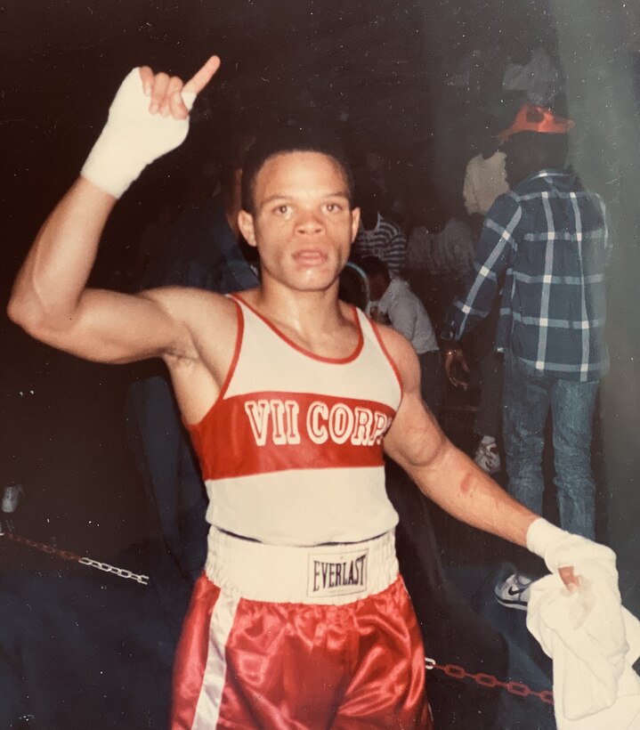 A young, male boxer poses for a photo.