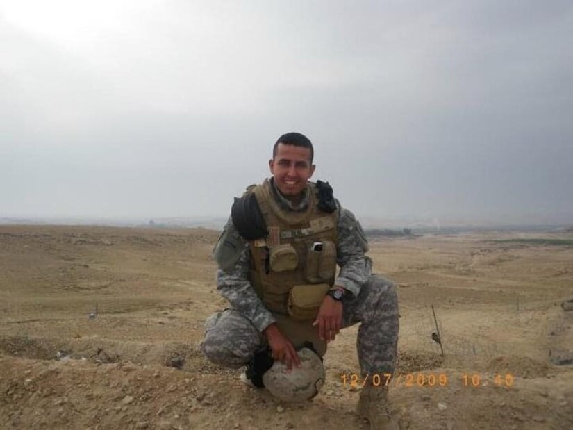 man in uniform wearing safety gear poses for a photo.