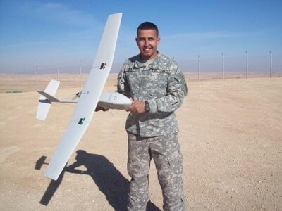 man standing holding a unmanned aircraft in his hand.