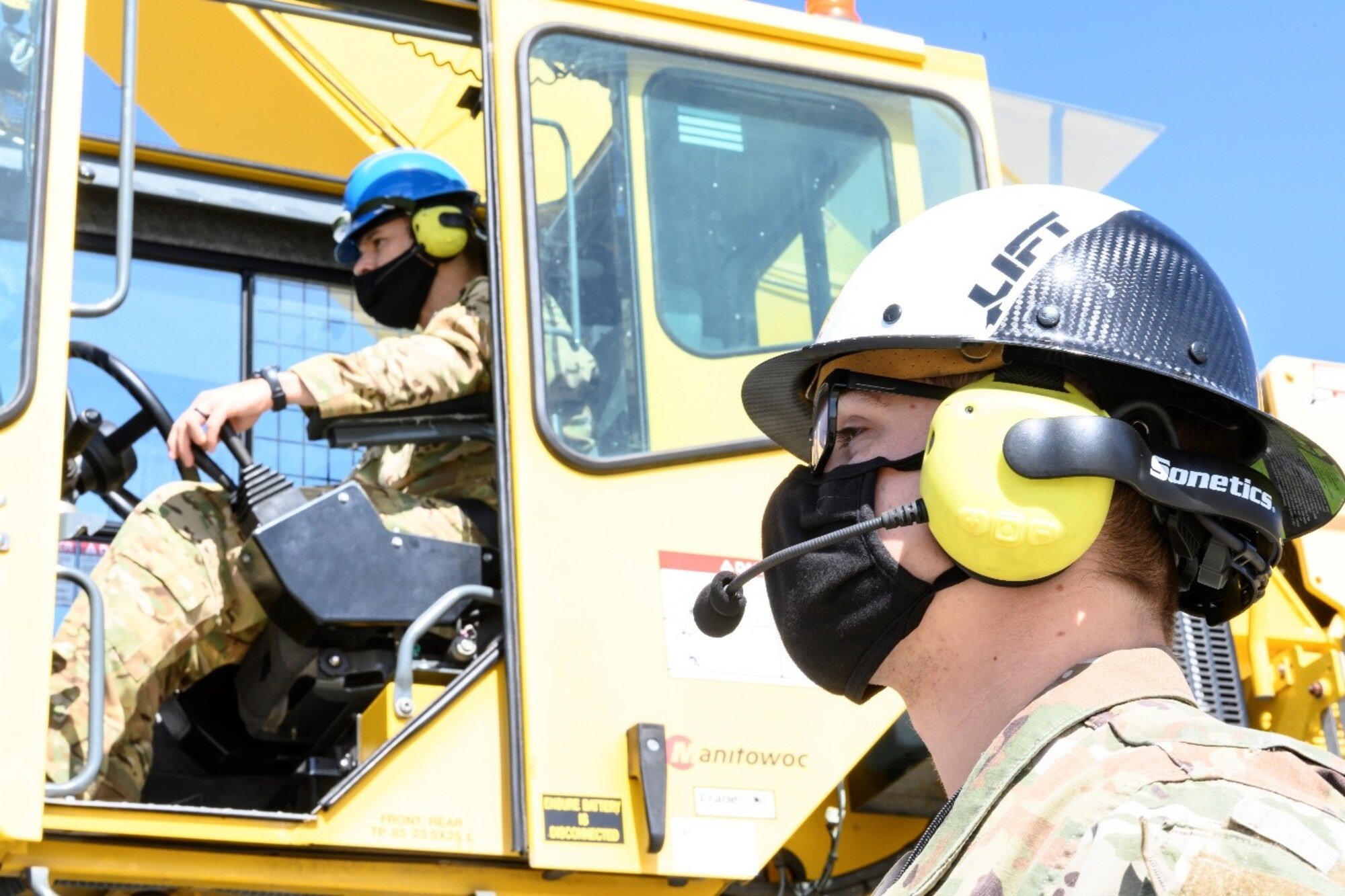U.S. Air Force Staff Sgt. Nikolas Darragh, right, 60th Maintenance Squadron assistant noncommissioned officer in charge of wheels and tires, explains via headset the proper use of a 50-ton crane to Col. Zachery Jiron, 60th Air Mobility Wing vice commander, May 7, 2021, at Travis Air Force Base, California. Jiron visited the 60th MXS during Leadership Rounds, a program that provides 60th AMW leadership an opportunity to interact with Airmen and receive a detailed view of each mission performed at Travis AFB.