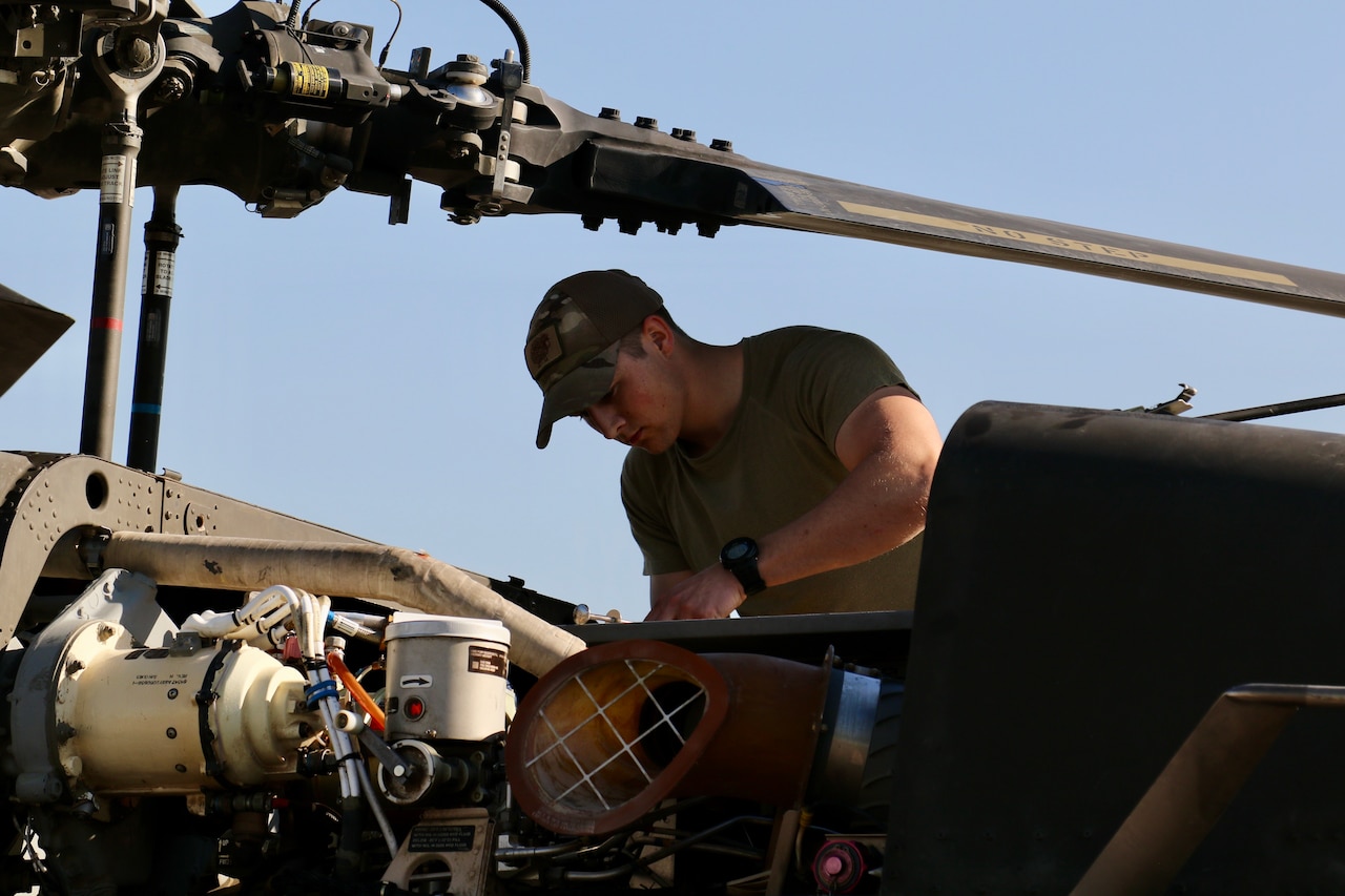 A man works on a helicopter.