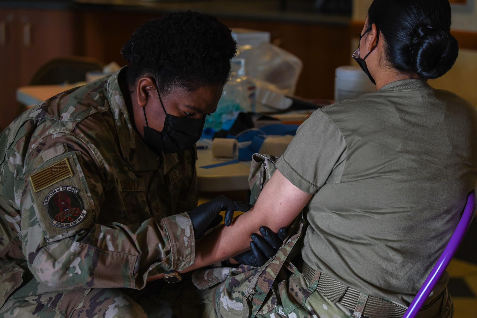Tech. Sgt. Kimberly Weaver, 606th Air Control Squadron noncommissioned officer in charge of medical readiness, checks for a vein before inserting a needle at Aviano Air Base, Italy, May 4, 2021. Independent Duty Medical Technicians are the only enlisted health care provider who can give care in the absence of a licensed, privileged or credentialed health care provider. (U.S. Air Force photo by Senior Airman Ericka A. Woolever)
