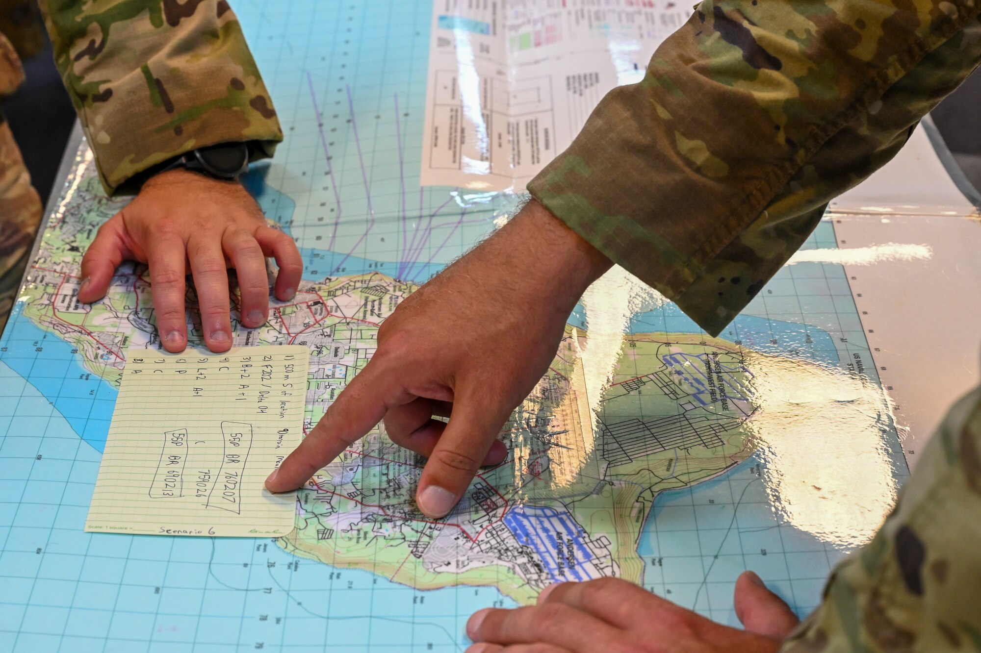 U.S. Air Force Airmen assigned to the 644th Combat Communications Squadron, use a map to plot coordinates during land navigation skills training on North West Field, Guam, April 9, 2021. Students spent three weeks learning various skills to help them in combat and survival during exercise Dragon Forge. Exercise DF is a combat skills training course that prepares participants to deploy to austere locations. (U.S. Air Force photo by Tech. Sgt. Esteban Esquivel)