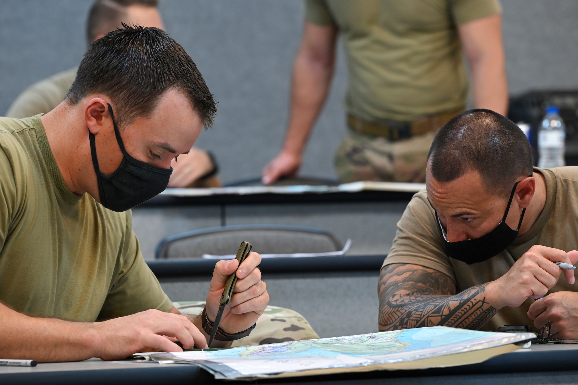 Dragon Forge participants practice plotting coordinates using a map during their classroom portion of training on North West Field, Guam, April 9, 2021. Exercise DF is a combat skills training course that prepares participants to deploy to austere locations. (U.S. Air Force photo by Tech. Sgt. Esteban Esquivel)