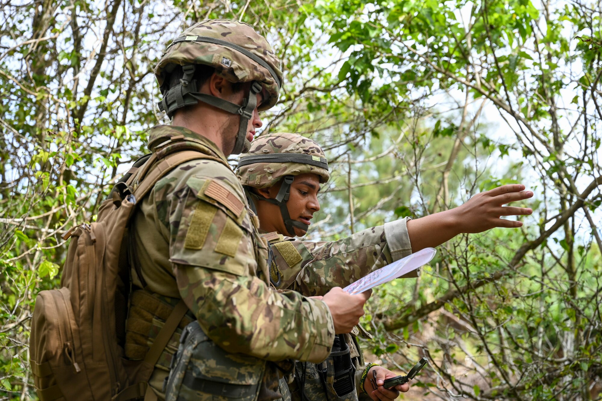 U.S. Air Force Airman 1st Class Adam Lixey and Airman 1st Class Brayan Rivera, systems technicians assigned to the 644th Combat Communications Squadron, practice their land navigation skills during exercise Dragon Forge on North West Field, Guam, April 13, 2021. Exercise Dragon Forge is a combat skills training course that prepares participants to deploy to austere locations. (U.S. Air Force photo by Tech. Sgt. Esteban Esquivel)