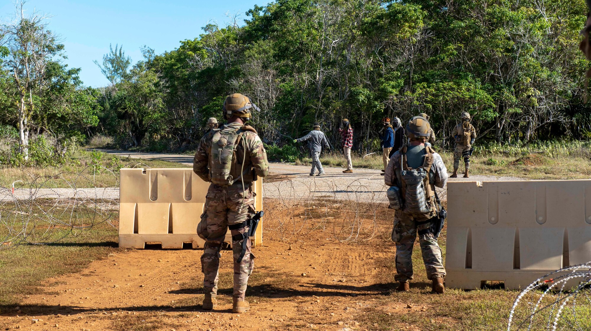 U.S. Air Force Airmen assigned to the 644th Combat Communications Squadron, stand guard at an entry control point during a field training exercise on North West Field, Guam, April 22, 2021. Students were tested on the skills and knowledge they gained over the past several weeks during exercise Dragon Forge. Exercise DF is a combat skills training course that prepares participants to deploy to austere locations. (U.S. Air Force photo by Senior Airman Helena Owens)