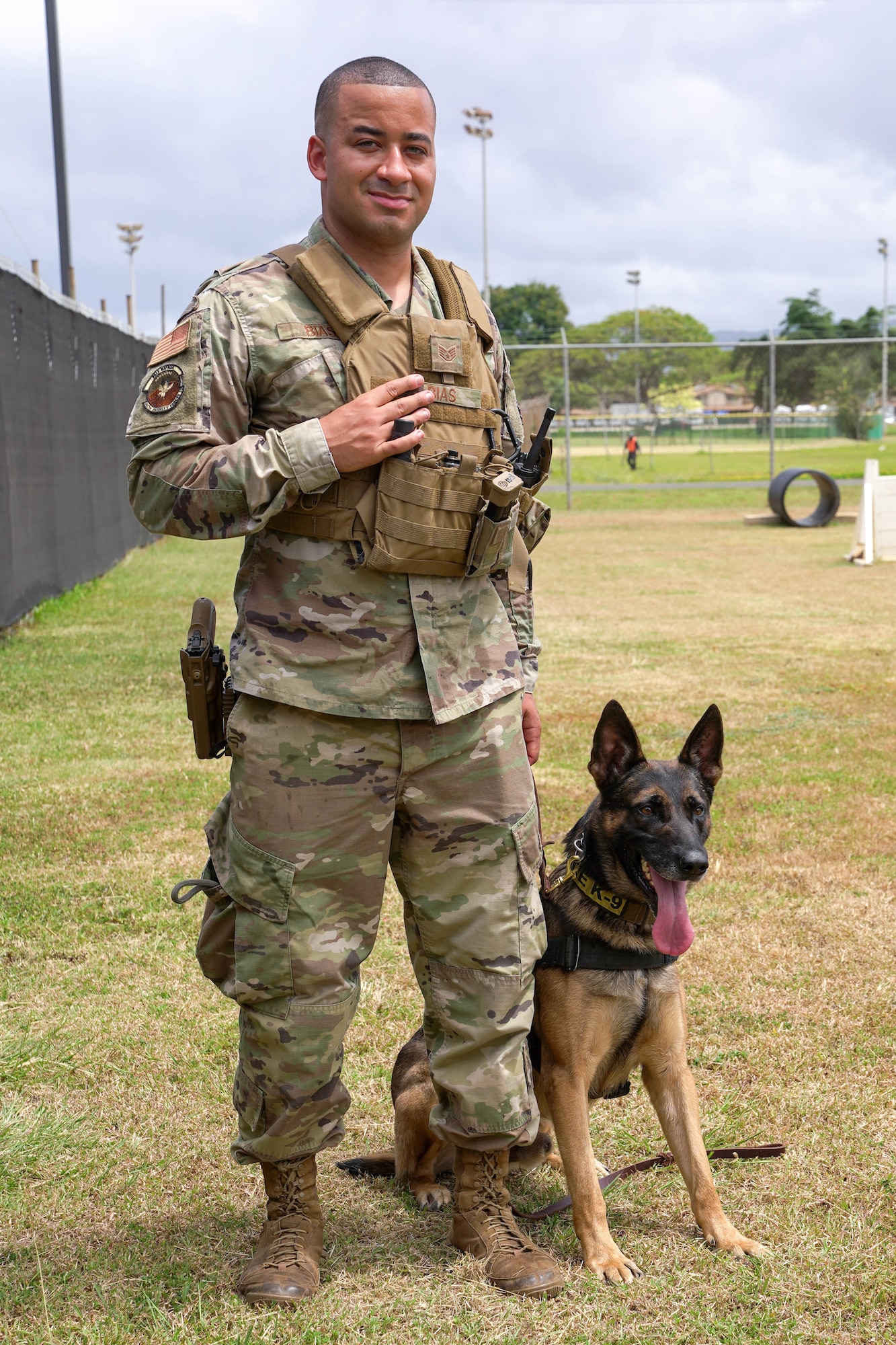 Staff Sgt. Tyrell Bias and Bagzi, 647th Security Forces military working dog handler and military working dog, train together at the obedience course at Joint Base Pearl Harbor-Hickam, Hawaii, May 7, 2021. Military working dogs conduct explosive and drug searches, search and recoveries, provide deterrence, and apprehend subjects. (U.S. Air Force photo by Airman 1st Class Makensie Cooper)