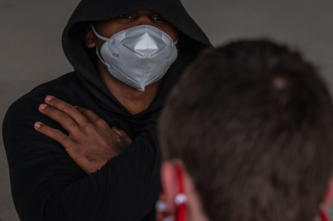 Man with mask looks at camera.