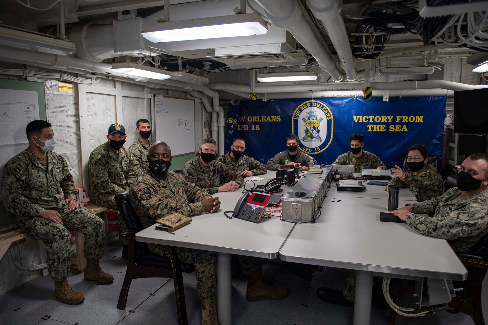 SASEBO, Japan (April 26, 2021) Staff of the 3D Marine Expeditionary Brigade (3D MEB), part of III Marine Expeditionary Force, and the USS New Orleans (LPD 18), part of Commander Task Force-76 (CTF-76), 7th Fleet, conduct a video teleconference onboard ship April 26 as part of Fleet Synthetic Training-Joint (FST-J). Pictured from 3D MEB are Maj. Jeff Adusei, Future Operations planner; Master Sgt. Justin Byrd, Fires and Effects Chief; and Maj. Brian Taylor, Air Planner. Teamwork between 3D MEB and CTF-76 greatly expands the network of resources that can be brought to bear on any given problem in any given location. New Orleans, part of the America Amphibious Ready Group, along with the 3D Marine Expeditionary Brigade, was operating in the U.S. 7th Fleet area of responsibility to enhance interoperability with allies and partners and serve as a ready response force to defend peace and stability in the Indo-Pacific region. (U.S. Navy photos by Mass Communication Specialist 2nd Class Kelby Sanders)