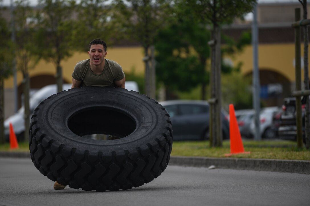 Airman Wesley J. Harding-Brown, 31st Security Forces Squadron (SFS) member, flips a tire during Police Week at Aviano Air Base, Italy, May 11, 2021. Airmen from the 31st SFS and 31st Civil Engineer Squadron competed in an obstacle course. The course consisted of a hose drag, litter carry, body drag, tire flips, Keiser FORCE Machine, sprints, M4 carbine assembly and disassembly, and a Humvee team push. (U.S. Air Force photo by Senior Airman Ericka A. Woolever)