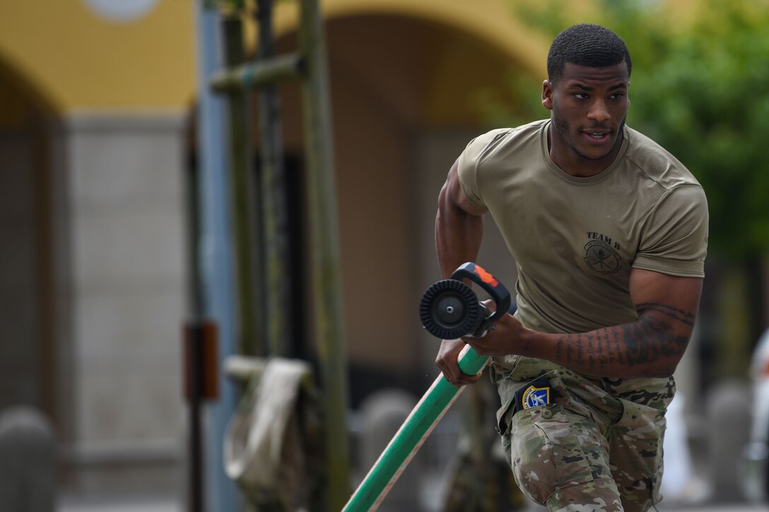 Airman Jamal R. Carter, 31st Security Forces Squadron (SFS) member, drags a fire hose during Police Week at Aviano Air Base, Italy, May 11, 2021. Airmen from the 31st SFS and 31st Civil Engineer Squadron competed in an obstacle course. The course consisted of a hose drag, litter carry, body drag, tire flips, Keiser FORCE Machine, sprints, M4 carbine assembly and disassembly, and a Humvee team push. (U.S. Air Force photo by Senior Airman Ericka A. Woolever)