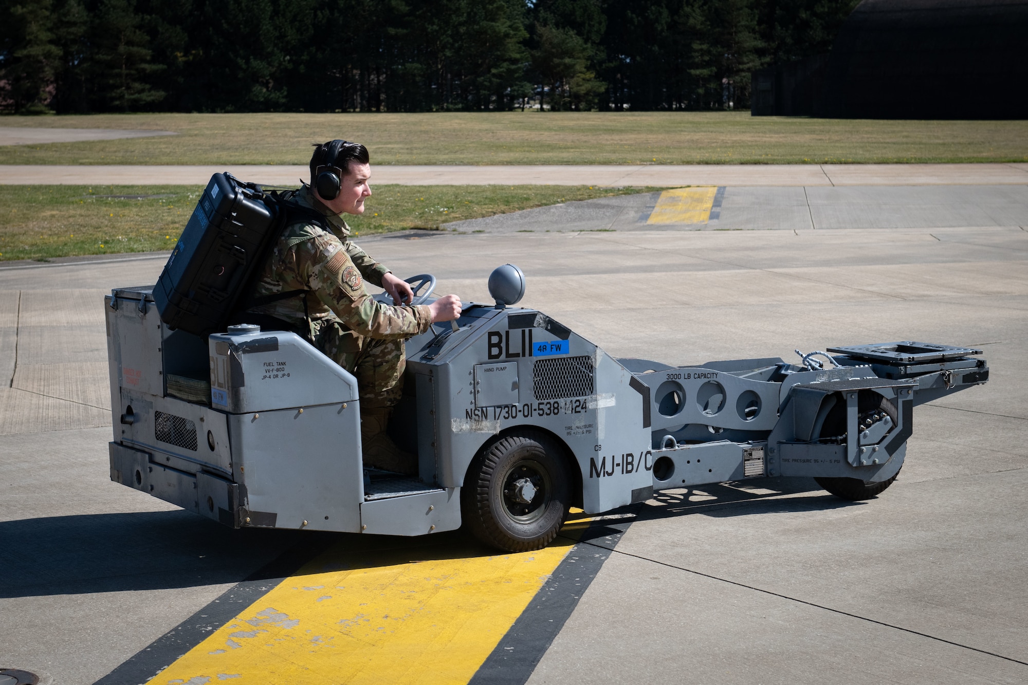 U.S. Air Force Senior Airman Shawn McIntosh, a weapons load crew member with the 492nd Aircraft Maintenance Unit, drives a MJ-IB/C bomb lift out to an aircraft with a Theater Readiness Tactical Line Equipment pack at Royal Air Force Lakenheath, England, April 22, 2021. Between packing, checking and loading the equipment up in preparation for a mission, these packs will save around 40 manpower hours for future ACE deployments on average. (U.S. Air Force photo by Airman 1st Class Airman Cedrique Oldaker)