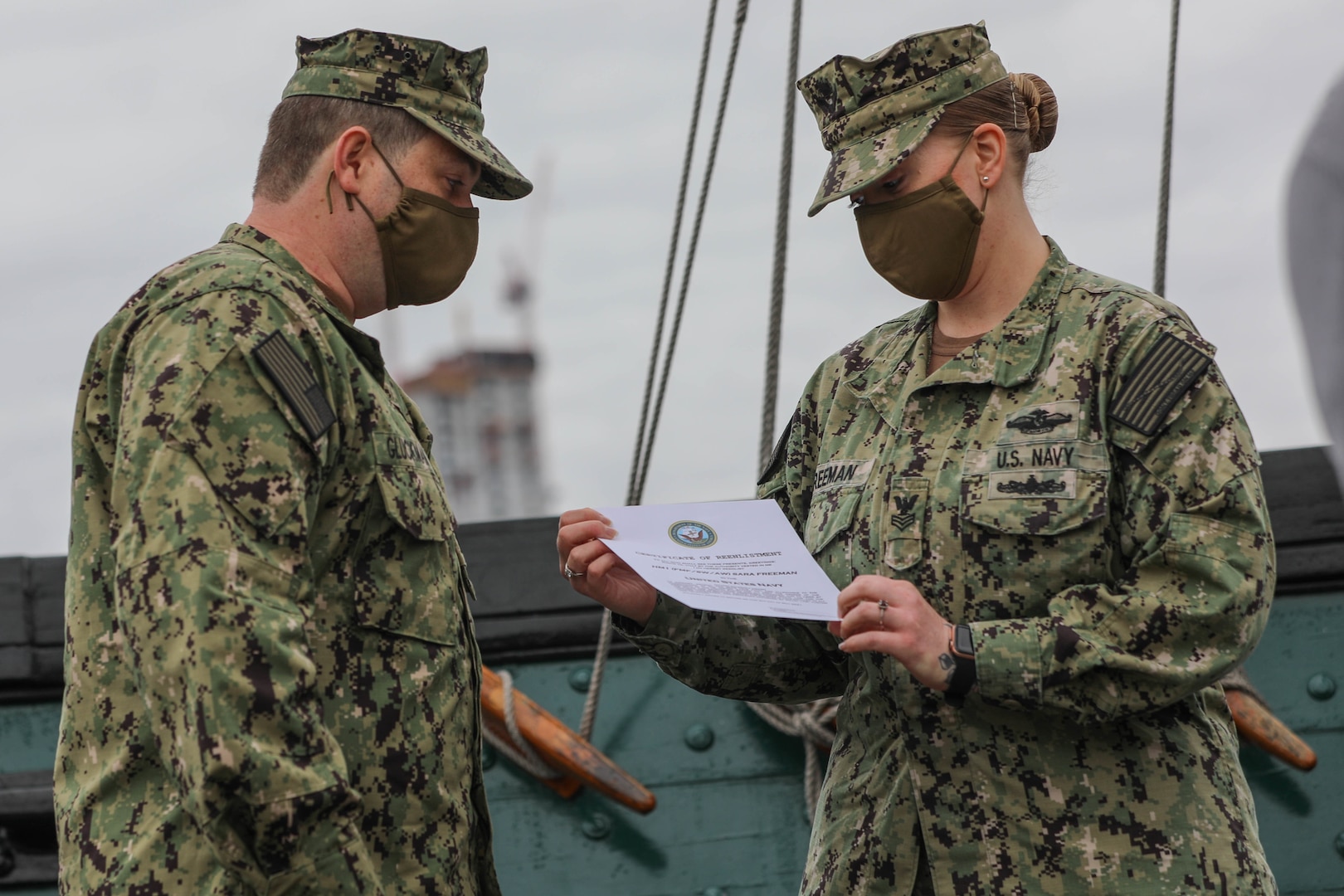 U.S. Navy Petty Officer 1st Class Sara Freeman, assigned to Naval Medical Center Portsmouth, Virginia, receives a certificate of reenlistment aboard the USS Constitution in the Boston Harbor, May 5, 2021.