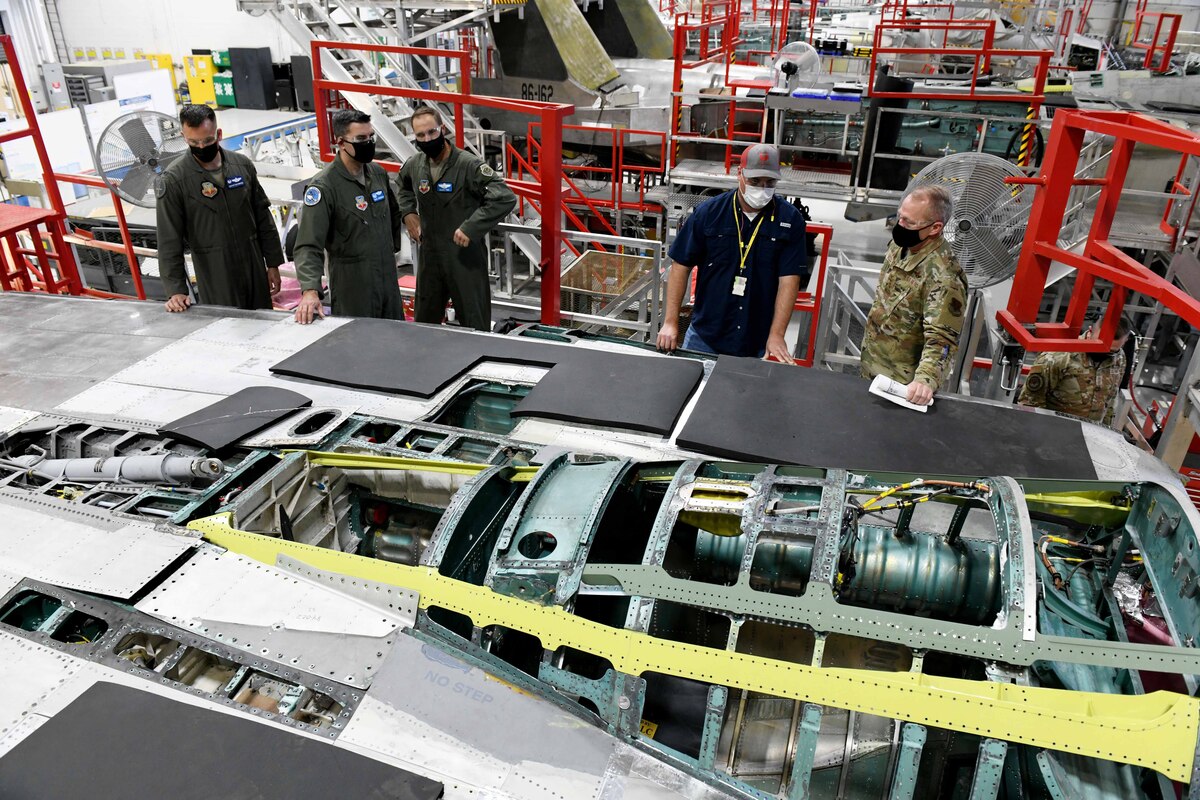 Photo shows group of people standing around a stripped down F-15 aircraft.
