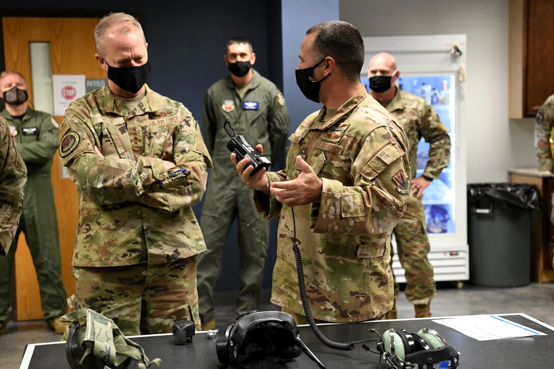 Photo shows group standing around equipment placed on table.
