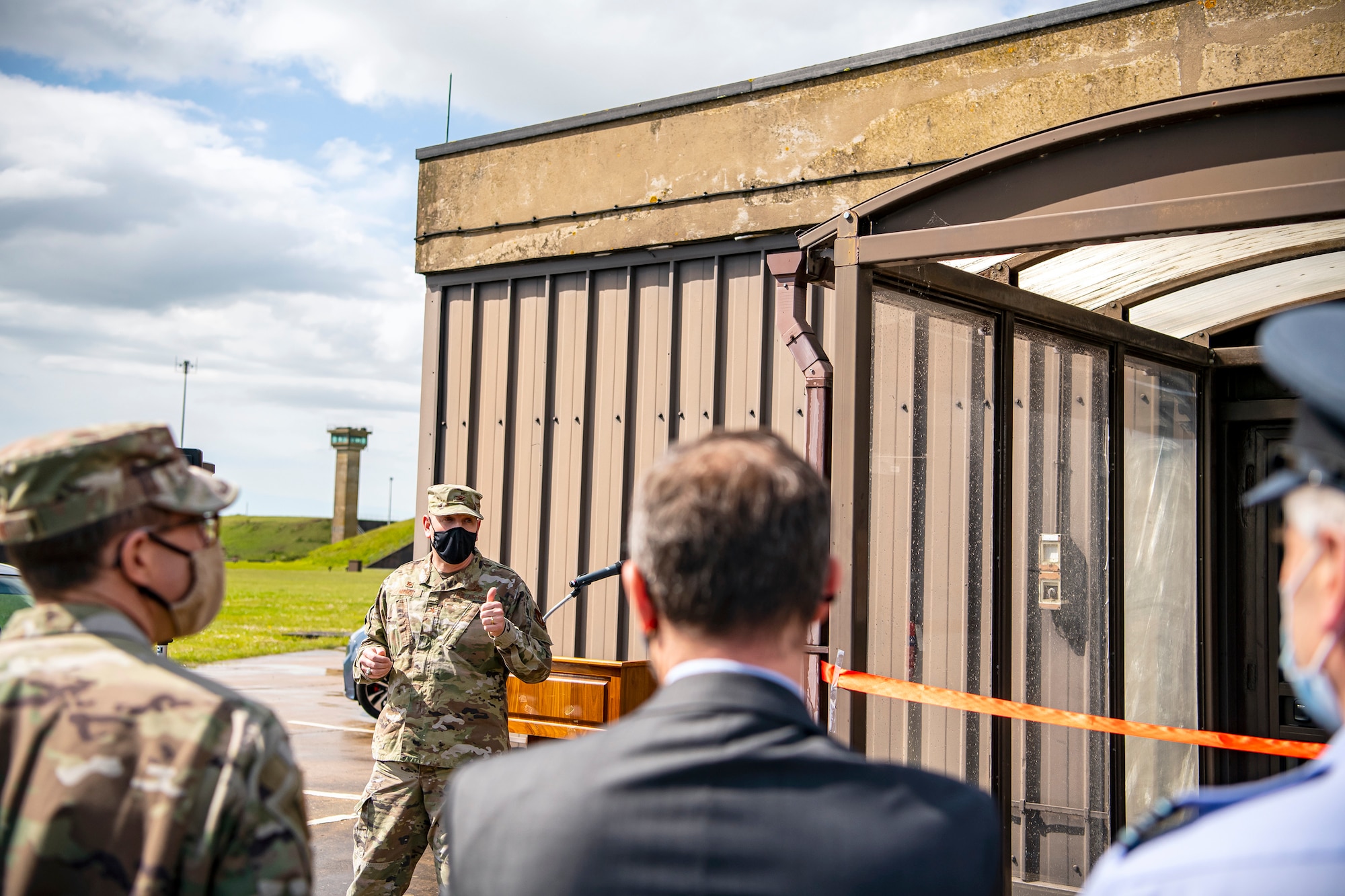 U.S. Air Force Col. Kurt Wendt, left center, 501st Combat Support Wing commander, speaks during a ribbon cutting ceremony at RAF Molesworth, England, May 11, 2021. Leadership from RAF Alconbury and RAF Molesworth attended the ceremony to celebrate the reopening of the base gym after months of refurbishing and renovations. (U.S. Air Force photo by Senior Airman Eugene Oliver)