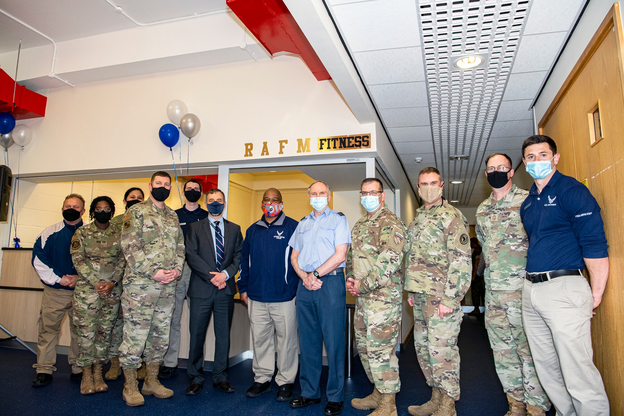 Leadership from RAF Alconbury and RAF Molesworth pose for a photo following a ribbon cutting ceremony at RAF Molesworth, England, May 11, 2021. Leadership from RAF Alconbury and RAF Molesworth attended a ribbon cutting ceremony to celebrate the reopening of the base gym after months of refurbishing and renovations. (U.S. Air Force photo by Senior Airman Eugene Oliver)