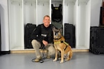 DIA Police Capt. William McEnaney poses for a photo with Norma Jean in the K-9 office in Reston, Va. (Photo by Ally Rogers, DIA Public Affairs)