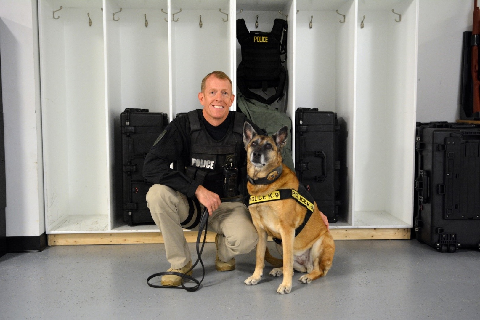 DIA Police Capt. William McEnaney poses for a photo with Norma Jean in the K-9 office in Reston, Va. (Photo by Ally Rogers, DIA Public Affairs)
