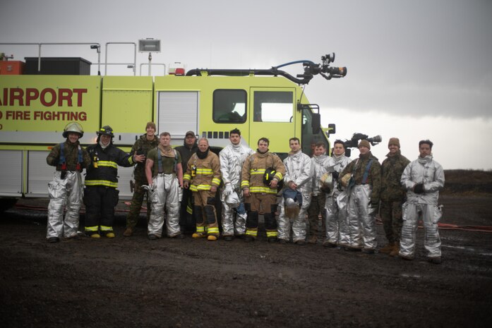 15th Marine Expeditionary Unit Marines and Sailors and Cold Bay Airport aircraft rescue firefighters pose for a photo in front of an Oshkosh Striker T3000 firetruck following a training event at Cold Bay Airport, Alaska in support of Northern Edge 2021. U.S. service members are participating in a joint training exercise hosted by U.S. Pacific Air Forces May 3-14, 2021, on and above the Joint Pacific Alaska Range Complex, the Gulf of Alaska, and temporary maritime activities area. NE21 is one in a series of U.S. Indo-Pacific Command exercises designed to sharpen the joint forces’ skills; to practice tactics, techniques, and procedures; to improve command, control and communication relationships; and to develop cooperative plans and programs.