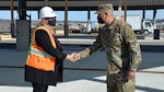 a military general officer shakes a woman's hand