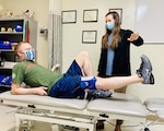 Research assistant, Kayla Enochs, directs BACH physical therapist Dr. Lee Webb, to raise his leg during a physical therapy session demonstrating exercises performed by Soldiers enrolled in a research study at BACH. Physical therapists at BACH partnered in a research project aimed at finding effective methods to treat service members with patellofemoral pain syndrome (PFPS), commonly known as runner’s knee. Their research found that Soldiers who used a neuromuscular electrical stimulation device, like the one Webb is wearing, in addition to an active home exercise program over a 9-week period experienced more improvement than Soldiers who only performed active home exercise. The study may help impact the methods used across the Army to treat PFPS. U.S. Army photo by Maria Yager.