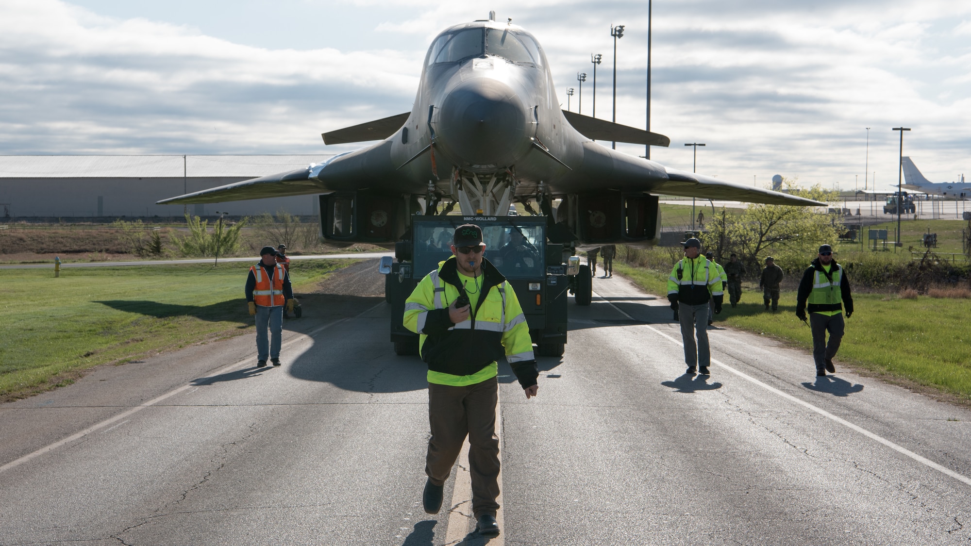 B-1B aircraft being towed down road.