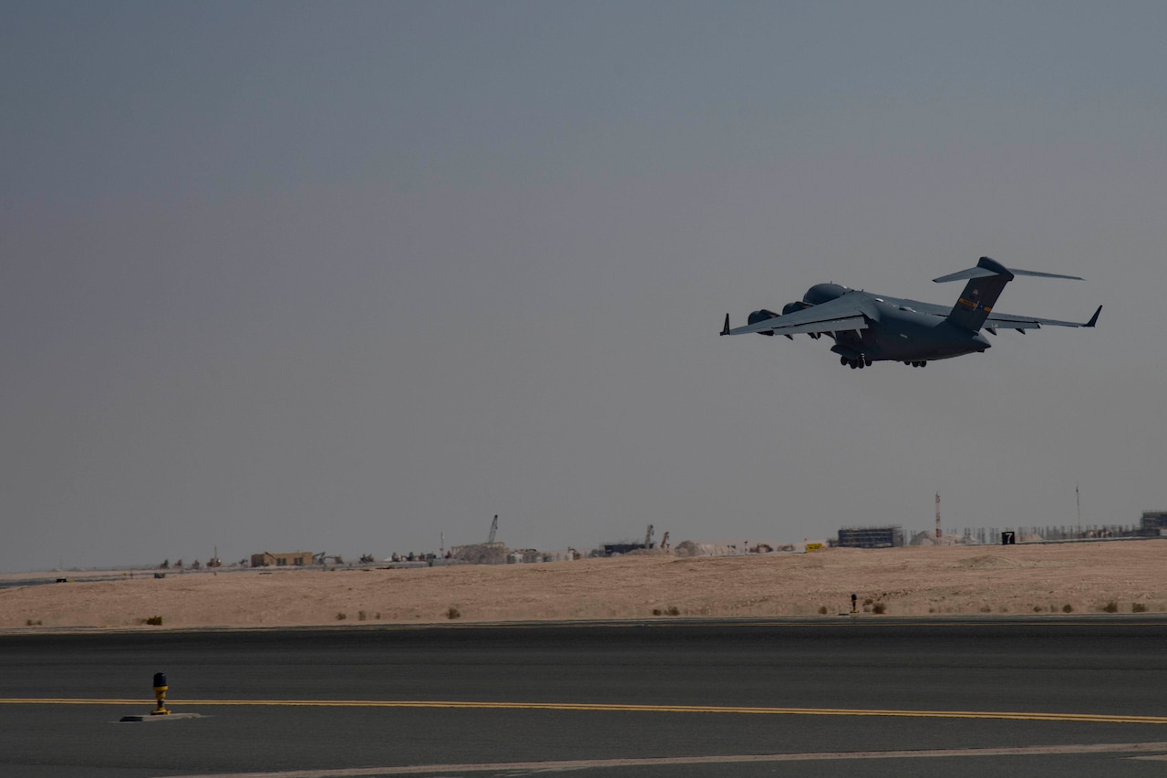 A cargo aircraft takes off from a desert runway.