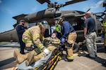 Firefighters from the Tulsa, Oklahoma Fire Department and EMSA personnel extract a simulated casualty played by an Oklahoma Army National Guard Citizen-Soldier from a mock helicopter crash during pre-accident training at the Oklahoma National Guard's Army Aviation Support Facility 2 in Tulsa, Oklahoma, May 12, 2021. Pre-accident training prepares Army aviation units to respond to accidents ranging from slip and falls to mass casualty events. (Oklahoma National Guard photo by Anthony Jones)