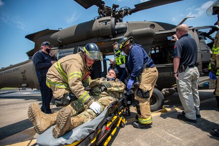 Firefighters from the Tulsa, Oklahoma Fire Department and EMSA personnel extract a simulated casualty played by an Oklahoma Army National Guard Citizen-Soldier from a mock helicopter crash during pre-accident training at the Oklahoma National Guard's Army Aviation Support Facility 2 in Tulsa, Oklahoma, May 12, 2021. Pre-accident training prepares Army aviation units to respond to accidents ranging from slip and falls to mass casualty events. (Oklahoma National Guard photo by Anthony Jones)