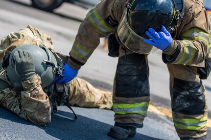 A fire fighter with the Tulsa, Oklahoma Fire Department checks the status of a simulated casualty played by an Oklahoma Army National Guard Citizen-Soldier during pre-accident training at the Oklahoma Army National Guard's Army Aviation Support Facility 2 in Tulsa, Oklahoma, May 12, 2021. Pre-accident training prepares Army aviation units to respond to accidents ranging from slip and falls to mass casualty events. (Oklahoma National Guard photo by Anthony Jones)