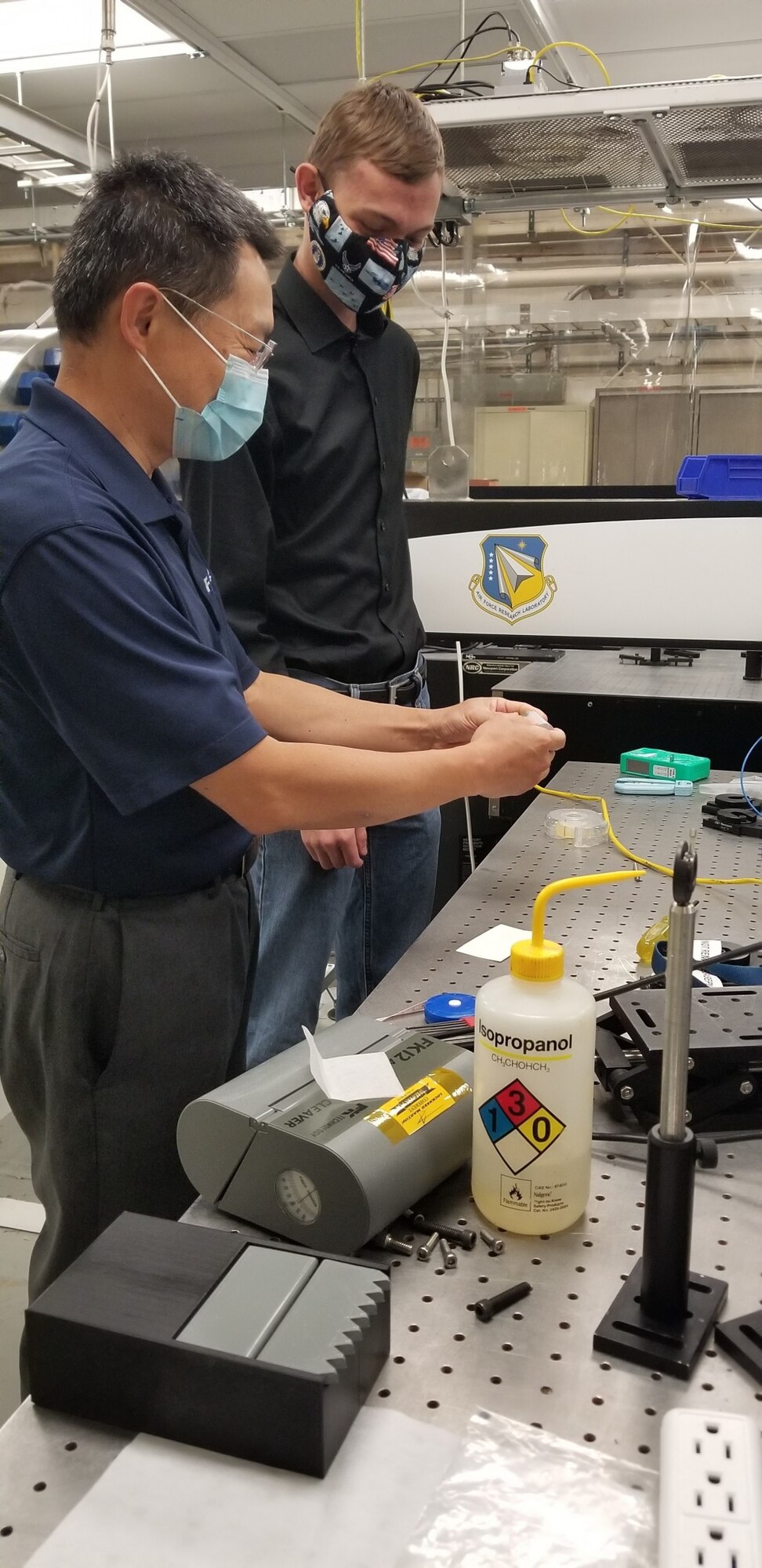 Scientist and student stand in research laboratory