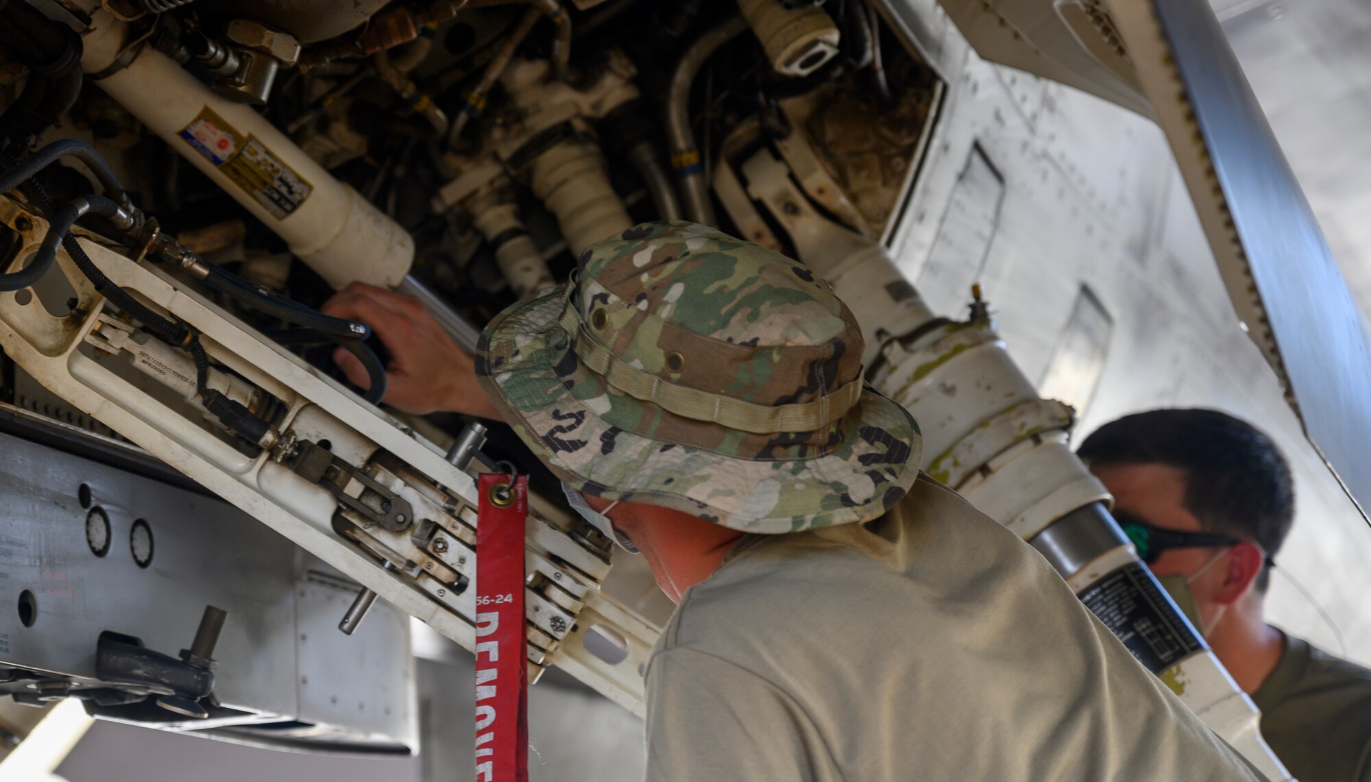 Senior Airman Scott Fure, 379th Expeditionary Maintenance Squadron C-130 crew chief, performs a demo of “hot pit” refueling training while Tech. Sgt. Richard Vice, 378th Expeditionary Operations Group quality assurance inspector, watches and gives instruction, Prince Sultan Air Base, Kingdom of Saudi Arabia, May 1, 2021. Hot pit refueling is where maintainers refuel an aircraft while the engine is still running, allowing the aircraft to safely and quickly return to flying. (U.S. Air Force Photo by Senior Airman Samuel Earick)