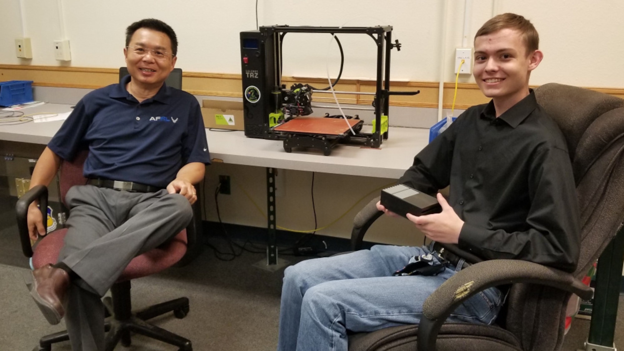 Scientist and student sit in office.