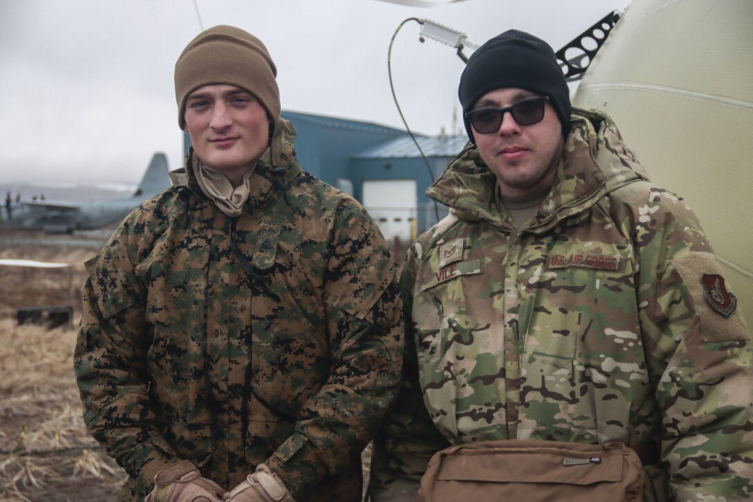 210506-M-JO645-1058 COLD BAY, ALASKA (May 6, 2021) – U.S. Marine Corps Cpl. Kyle Bradford, left, a satellite transmissions operator and native of Paris, KY, with Joint Task Force Enablers, 15th Marine Expeditionary Unit, and U.S. Air Force Tech. Sgt. Matthew Vile, a cyber control operator and native of Harper’s Ferry, West Virginia, with 673d Communication Squadron, Joint Base Elmendorf-Richardson, Alaska, pose for a photo during Northern Edge 2021. U.S. service members are participating in a joint training exercise hosted by U.S. Pacific Air Forces May 3-14, 2021, on and above the Joint Pacific Alaska Range Complex, the Gulf of Alaska, and temporary maritime activities area. NE21 is one in a series of U.S. Indo-Pacific Command exercises designed to sharpen the joint forces’ skills; to practice tactics, techniques, and procedures; to improve command, control and communication relationships; and to develop cooperative plans and programs. (U.S. Marine Corps photo by Sgt. Desiree King)