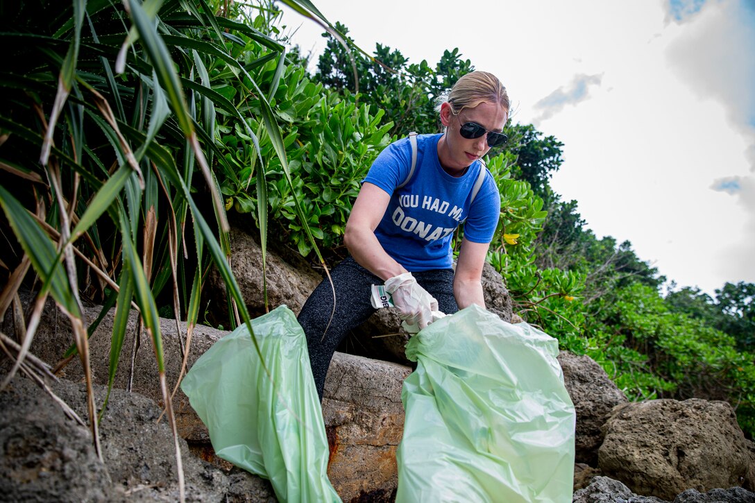U.S. Marine Corps Sgt. Elizabeth Adams, a metal worker with 3d Maintenance Battalion, 3d Marine Logistics Group, collects trash to be discarded properly at the Earth Day cleanup on Kaa-Mii-Jii, Okinawa, Japan, May 7, 2021. Hosted by the Single Marine Program, weekly cleanups allow service members the opportunity to maintain cleanliness on and off base, and to help strengthen the U.S.-Japan alliance to protect the force and keep the Okinawan environment clean. The cleanup, postponed twice due to inclement weather, was hosted to raise awareness for Earth Day. Adams is a native of Jones, Alabama. (U.S. Marine Corps photo by Lance Cpl. Alex Fairchild)