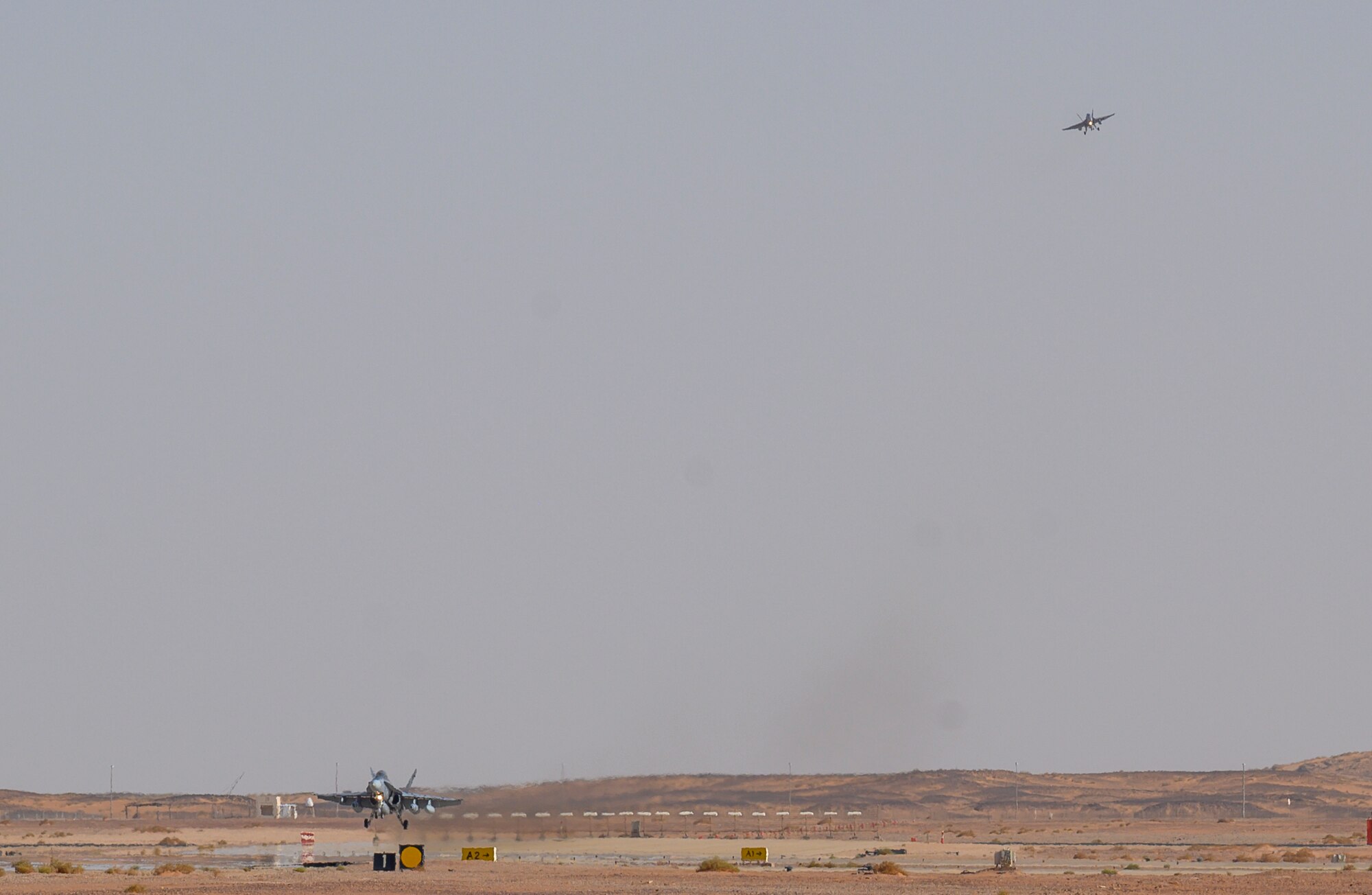 A U.S. Marine Corps F/A-18D Hornet lands on the flightline at Prince Sultan Air Base, Kingdom of Saudi Arabia, May 8, 2021, while another prepares to land behind it. A detachment of F/A-18s, along with squadron personnel from Marine Corps Air Station Beaufort, South Carolina, will rapidly integrate into theater training, as well as joint and partnered missions, as part of a dynamic force employment highlighting the U.S. military’s ability to rapidly deploy and employ forces anywhere around the globe. (U.S. Air Force photo by Senior Airman Samuel Earick)