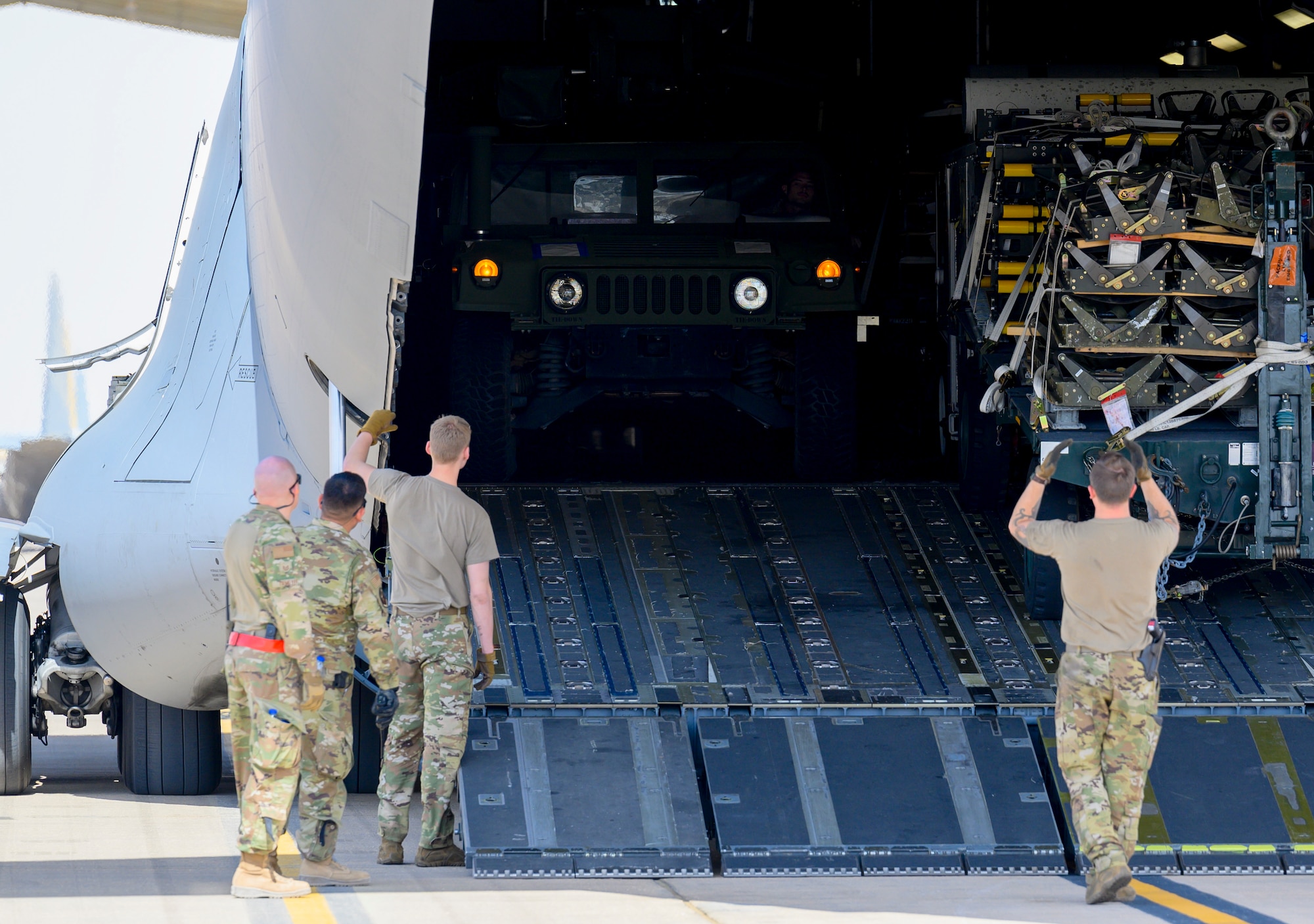 Members of the 378th Expeditionary Logistics Readiness Squadron Air Terminal Operations Center unload a HUMMWV from a U.S. Air Force C-17 at Prince Sultan Air Base, Kingdom of Saudi Arabia, May 5, 2021. Personnel, aircraft, and supplies from Marine All Weather Fighter Attack Squadron 224, Marine Aircraft Group 31, deployed as part of a dynamic force employment to PSAB from Marine Corps Air Station Beaufort, South Carolina, to enhance U.S. Central Command’s ability to deter aggression and promote security and stability within the USCENTCOM area of responsibility. (U.S. Air Force photo by Senior Airman Samuel Earick)