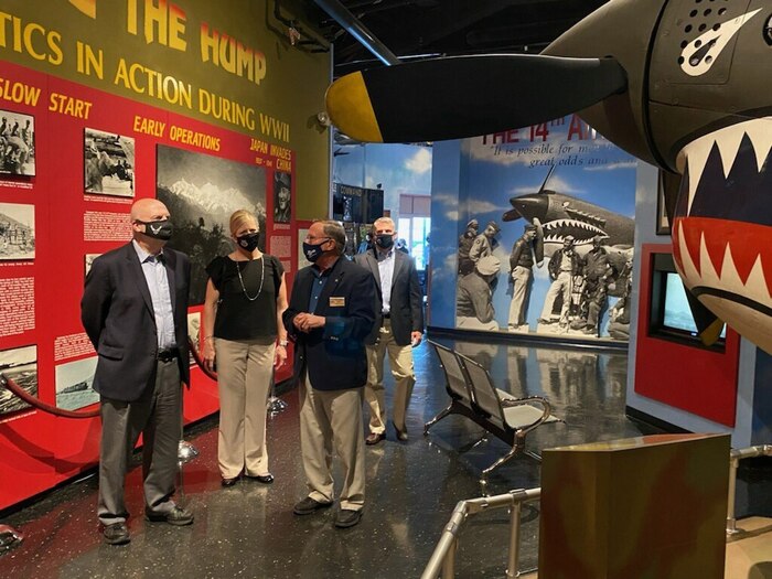 Photo shows group standing in front of an indoor airplane exhibit.
