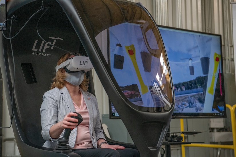 A woman pilots an aircraft simulator.