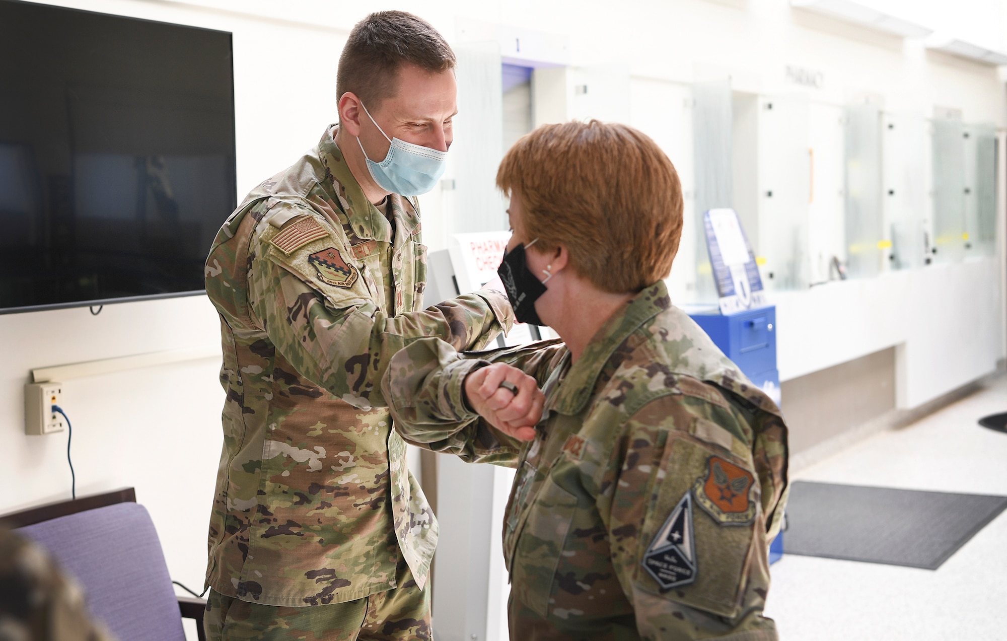 Air Force Surgeon General Lt. Gen. Dorothy Hogg bumps elbows with Capt. Scott Coberly, 66th Medical squadron pharmacist, after presenting him a coin at Hanscom Air Force Base, Mass., May 11. During her visit to the 66 MDS clinic, Hogg coined four star performers for their efforts throughout COVID-19. (U.S. Air Force photo by Lauren Russell)