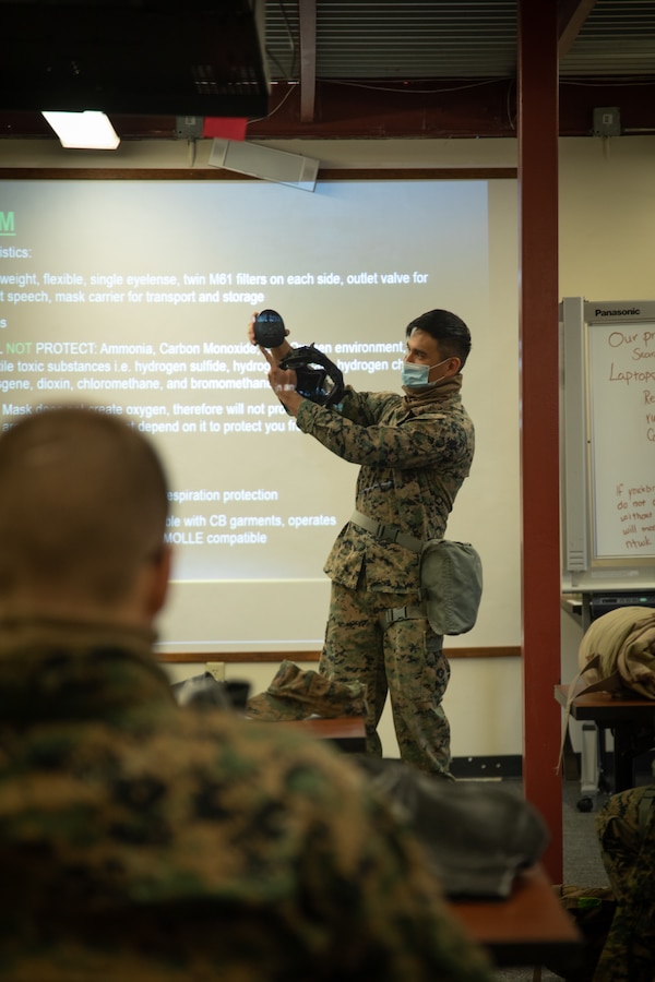 Cpl. Gerard Macalino, a Chemical, Biological, Radiological, and Nuclear (CBRN) Defense Specialist with Marine Aircraft Group 41, 4th Marine Aircraft Wing, explains proper use of the M50 joint service general-purpose mask, to Marines during a class on CBRN individual safety measures, during Arctic Care 2021 in Kodiak, Alaska, on May 7, 2021. Arctic Care 2021 is a joint-service training mission that provides medical, dental and optometric care to residents of Kodiak Island, Alaska. . (U.S. Marine Corps photo by Lance Cpl. James Stanfield)