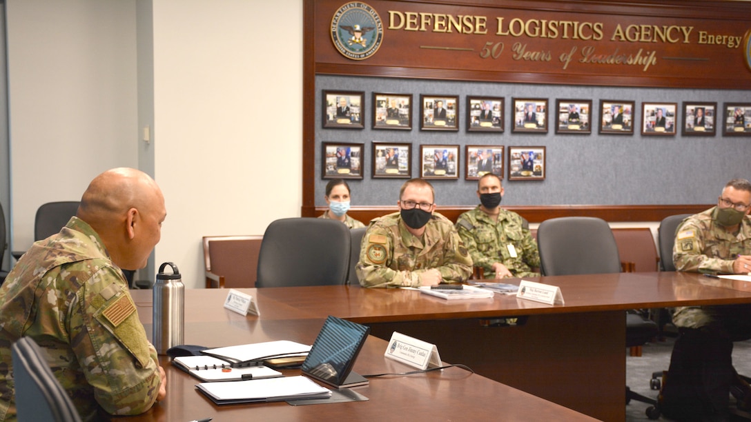 two men in uniform sit at a table talking