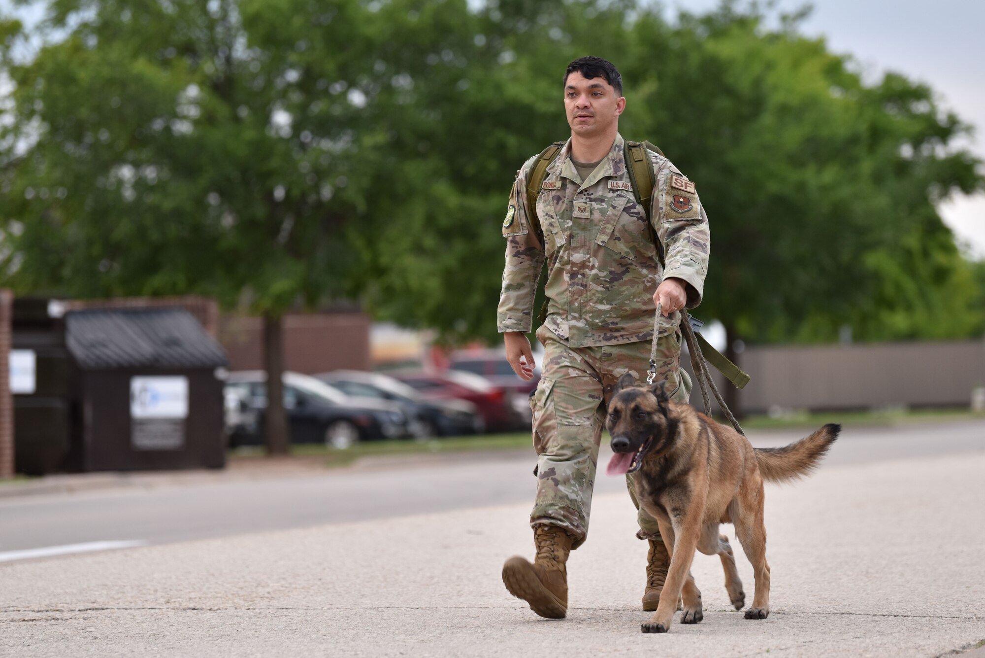 U.S. Air Force Staff Sgt. Nicholas Suitonu, 17th Security Forces Squadron military working dog handler, walks with Zekk, 17th SFS MWD, during a ruck around Goodfellow Air Force Base, Texas, May 10, 2021. The ruck was the first of several events held during National Police Week. (U.S. Air Force photo by Staff Sgt. Seraiah Wolf)