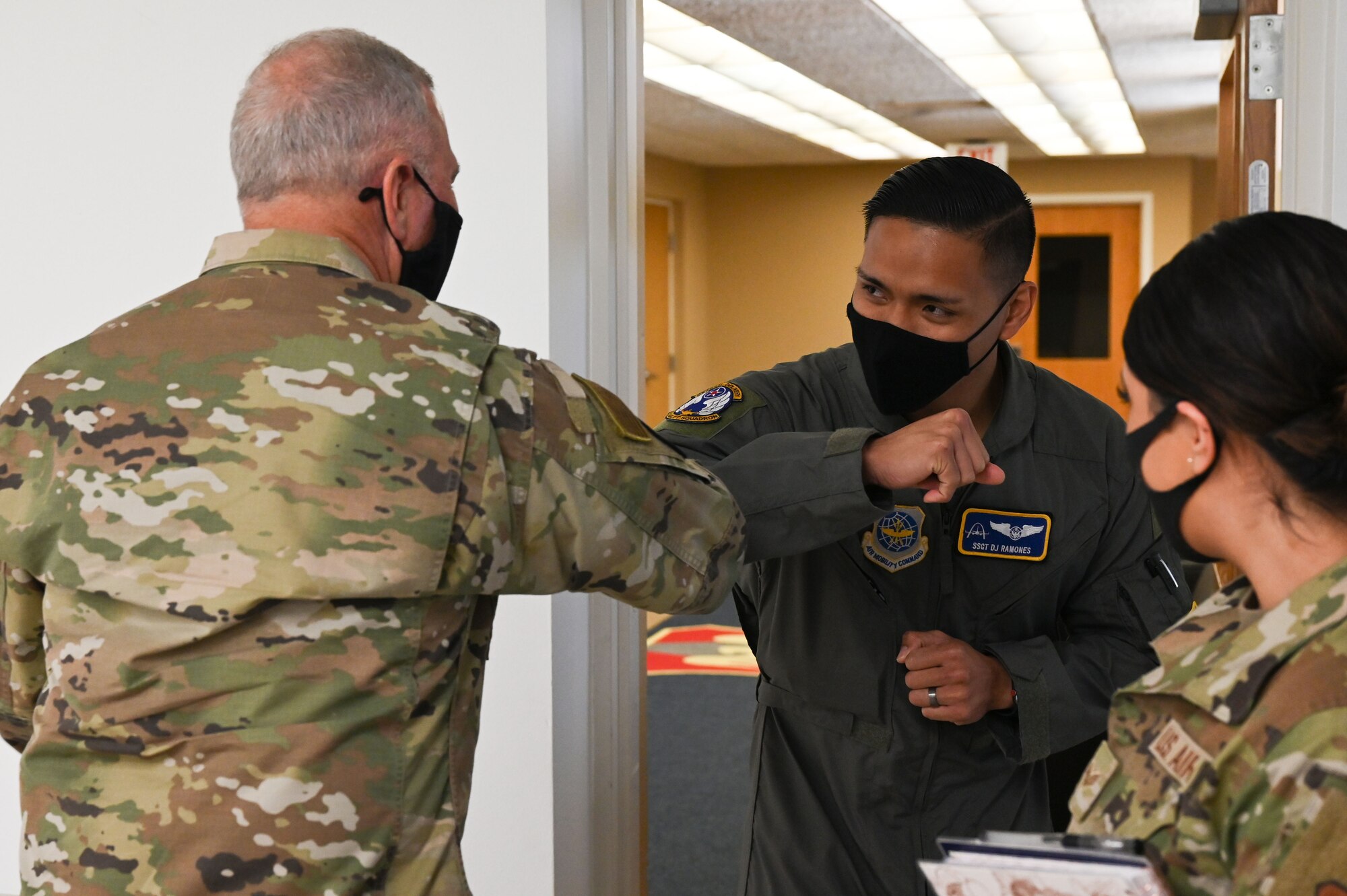 Two men elbow bump in greeting.