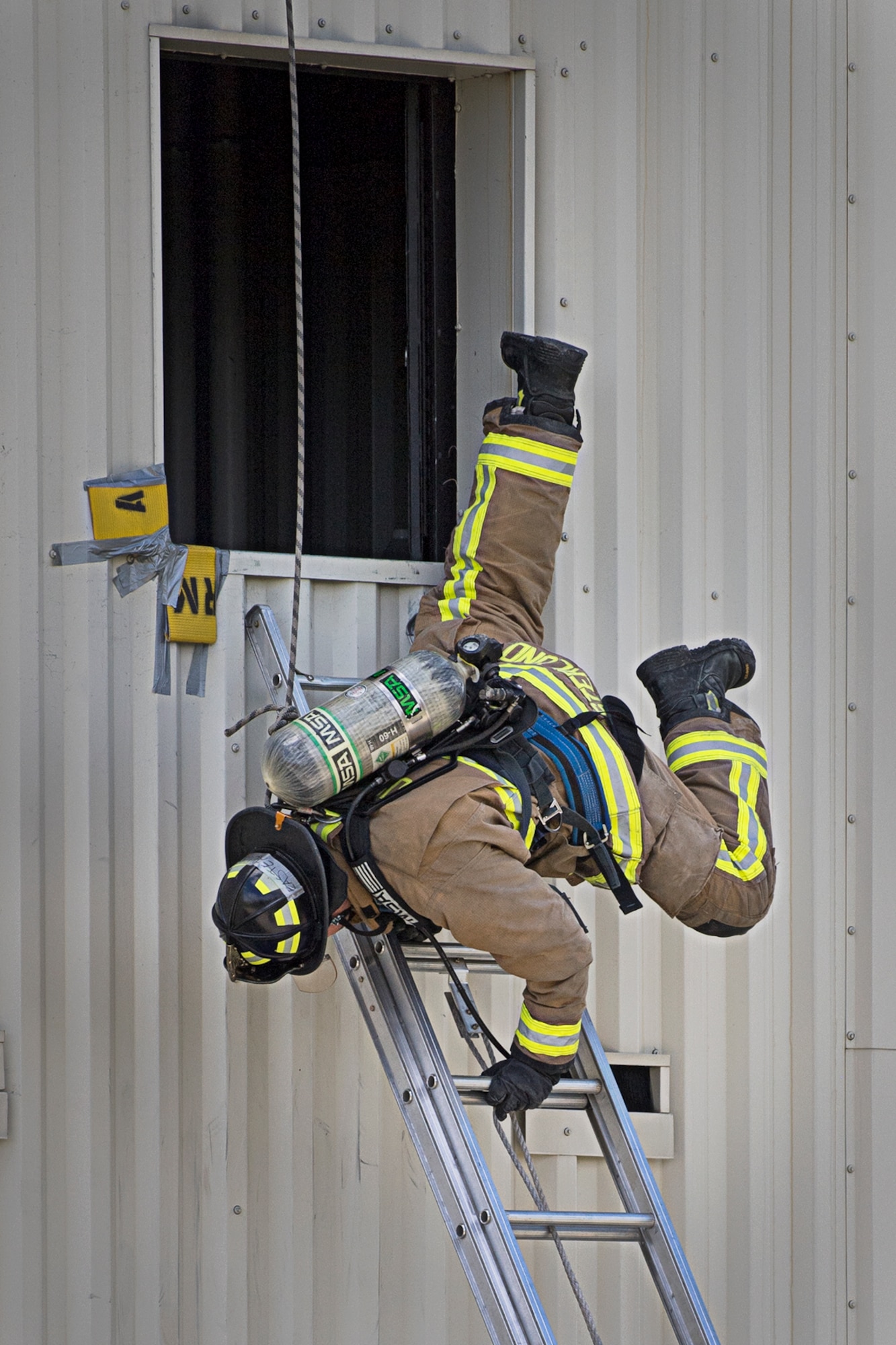 Jordan Easterlund, a firefighter from Tinker Air Force Base, Okla., spins around as he egresses a second story window head first May 11, 2021 at Grissom ARB, Indiana. Firefighters from six locations gathered here to train in firefighting rescue and survival tactics May 10-14. (Air Force photo by Douglas Hays)