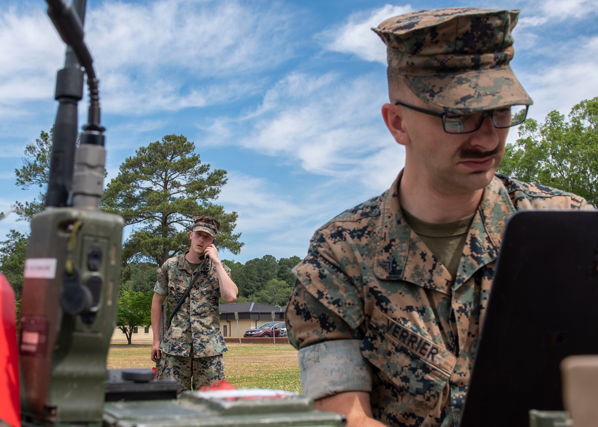 Cpl. Zachary Verrier, right, programs a secure communications controller while Cpl. David Hedges, both field radio operators with Headquarters Battalion Company 2nd Marine Division, performs operational checks on a PRC-117G radio at Seymour Johnson Air Force Base, North Carolina, May 5, 2021.